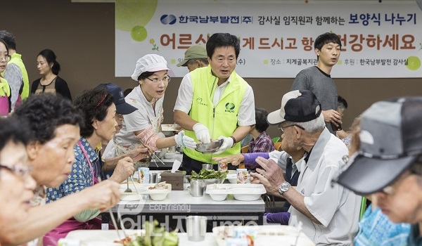 한국남부발전 유구현 상임감사위원(가운데)이 어르신들께 배식봉사를 하고 있다.