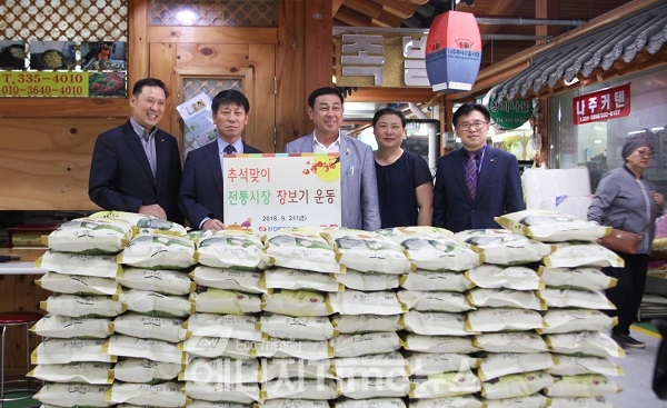 한전KPS 박정수 경영관리본부장(왼쪽 두번째)과 본사 직원들이 21일 나주시 목사골시장을 방문, 쌀을 구입하고 기념촬영을 하고 있다.