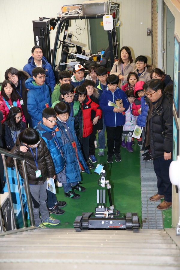 학생들이 로봇 연구실에서 무인 대응 로봇 시연을 관람 중이다.