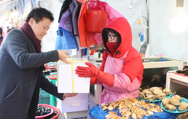 동서발전 임직원이 울산농수산물도매시장을 방문해 물품을 구입하고 있다.