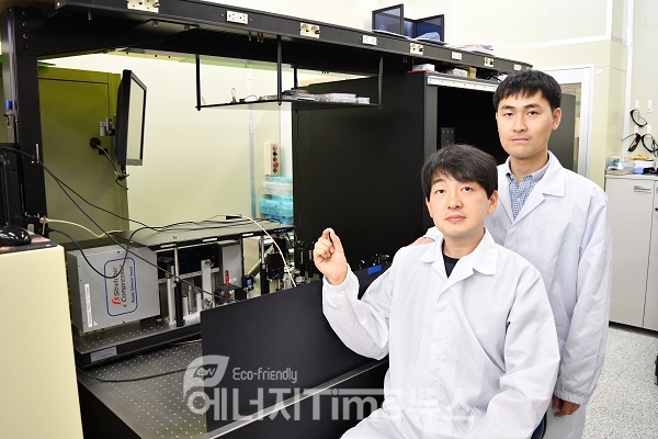 연구개발자인 정보수 선임(앞)과 이병학 선임이 펨토초 레이저 장비 앞에서 표면처리 된 티타늄을 들고 포즈를 취하고 있다.