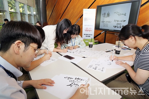 한국동서발전 직원들이 청렴 문구를 담은 캘리그라피를 작성하고 있다.
