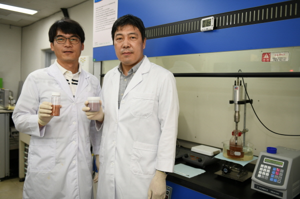 전기연구원 핵심개발자인 정희진 박사(왼쪽)와 이건웅 박사(오른쪽)가 구리-그래핀 복합파우더와 잉크를 각각 들고 포즈를 취하고 있다.