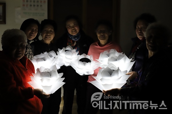 마을 주민들이 폐그물 업사이클링 전등을 설치하기 전 마을회관에서 기념촬영을 하고 있다.