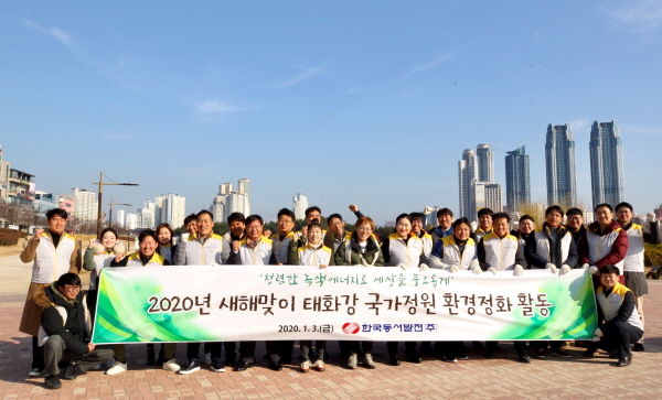 한국동서발전 임직원들이 태화강 국가정원에서 환경정화 활동 기념 사진 촬영을 하고 있다.