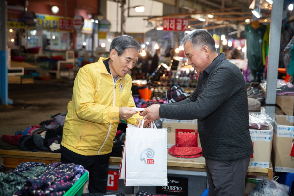 김병숙 한국서부발전 사장(왼쪽)이 충남 태안군 서부시장에서 태안사랑 상품권을 이용해 물품을 구입하고 있다.