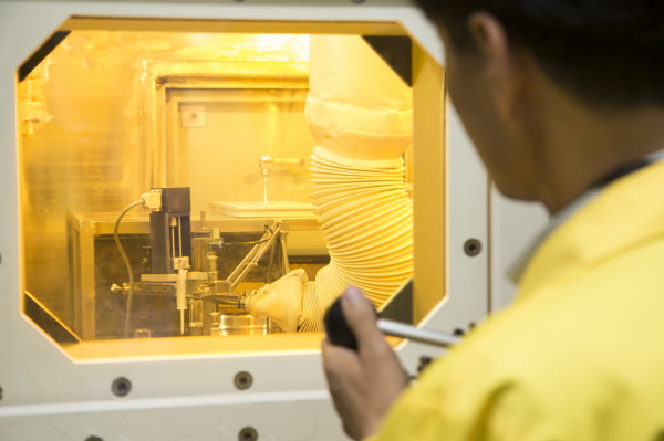 연구원이 로봇팔로 방사성동위원소 생산 작업을 하고 있다.