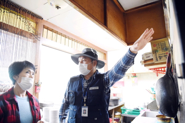 상가에서 전기안전요령을 알려주고 있는 공사 직원 모습