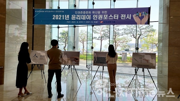 한국전력기술 윤리데이 행사에서 직원들이 본사 1층 로비에 전시된 국가인권위원회 인권공모전 포스터 수상작을 관람하고 있다.