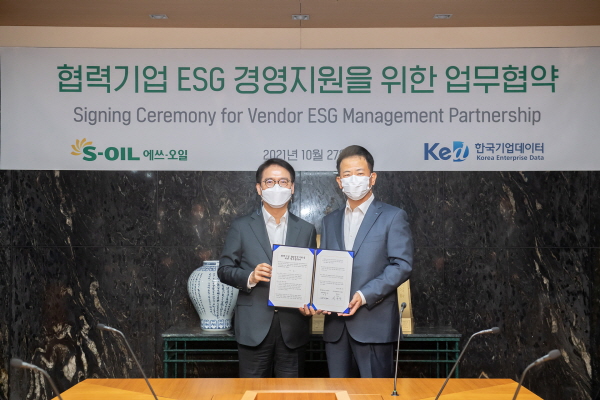 류열 에쓰-오일 사장(왼쪽)과 이호동 한국기업데이터 대표(오른쪽)가 27일 서울 마포 에쓰-오일 본사 사옥에서 협력사 ESG 경영지원 협약을 체결한 뒤 기념촬영을 하고 있다.