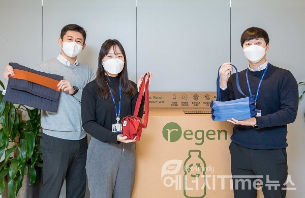 효성티앤씨 직원들이 사내 페트병 수거함 앞에서 친환경 섬유 리젠으로 만든 가방을 선보이고 있다.