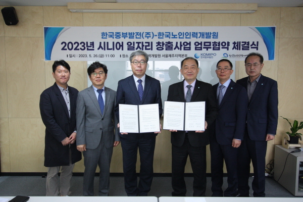 5월 26일(금) 김호빈 중부발전 사장(왼쪽 네 번째)과 김미곤 한국노인인력개발원장(왼쪽 세 번째) 등 참석자들이 협약서를 들고 기념촬영을 하고 있다.