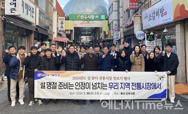 한국동서발전 임직원들이 선우시장 앞에서 전통시장 장보기 기념 사진 찍는 모습