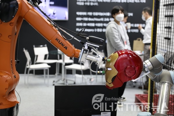 지능형 협업 로봇이 부품을 조립하는 스마트 제조 공정을 부스에서 시연하는 이미지.